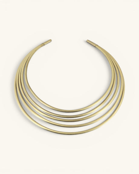 Hand-beaten brass multi-band collar necklace, front view on cream background showing five smooth curved bands
