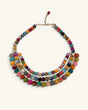 Colorful textile-wrapped bead layered necklace flat lay, front view showing multicolor bib design and gold chain clasp