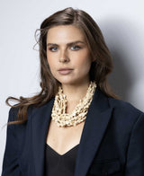 Cultural Elements beige wood disc layered necklace with horn eye and hook closure.