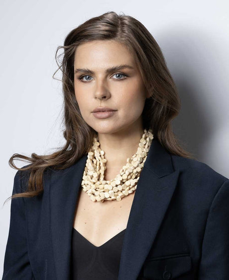 Cultural Elements beige wood disc layered necklace with horn eye and hook closure.