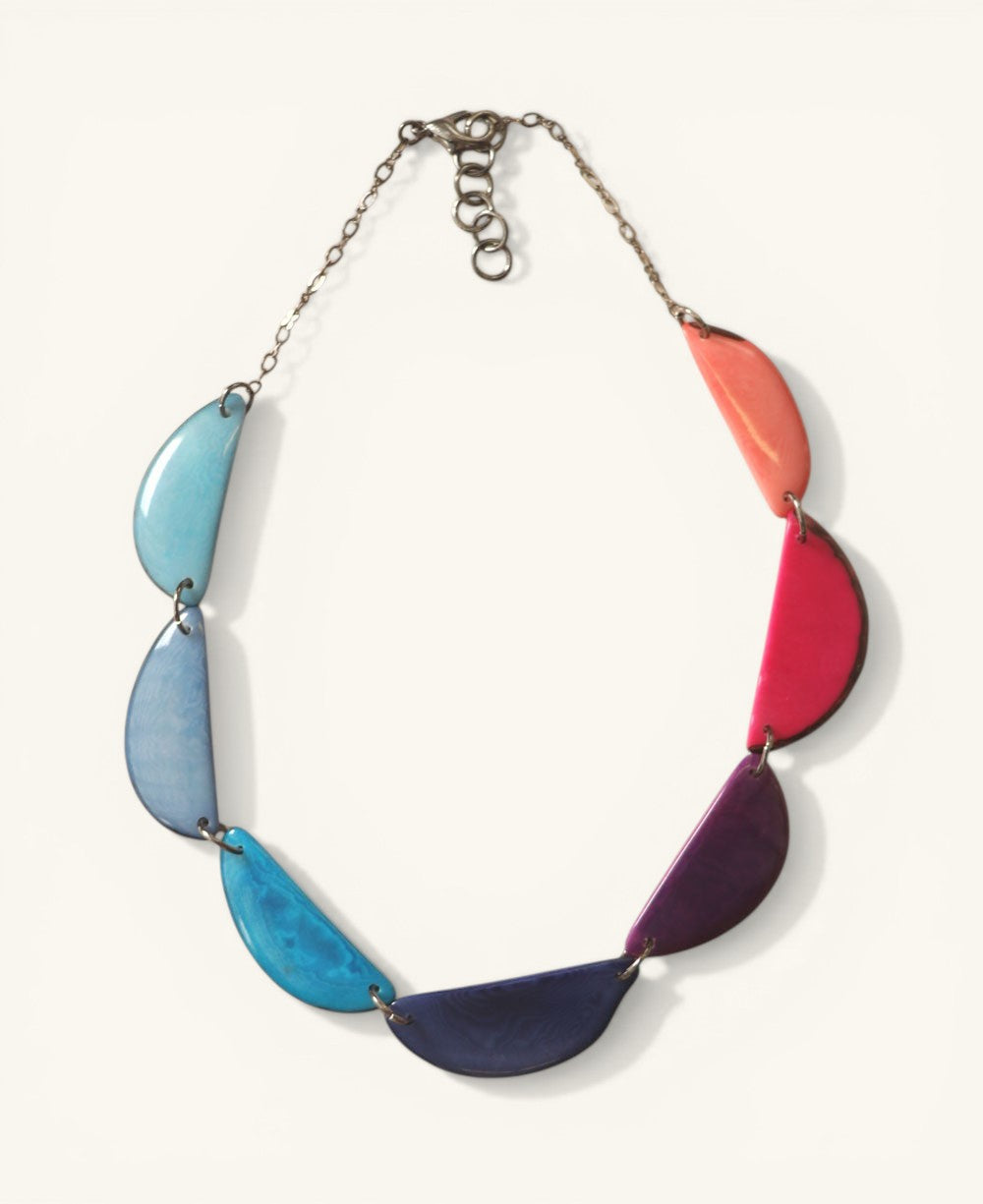 Cultural Elements vibrant crescent Tagua necklace with blue, purple, pink, and orange hues. Adjustable length.