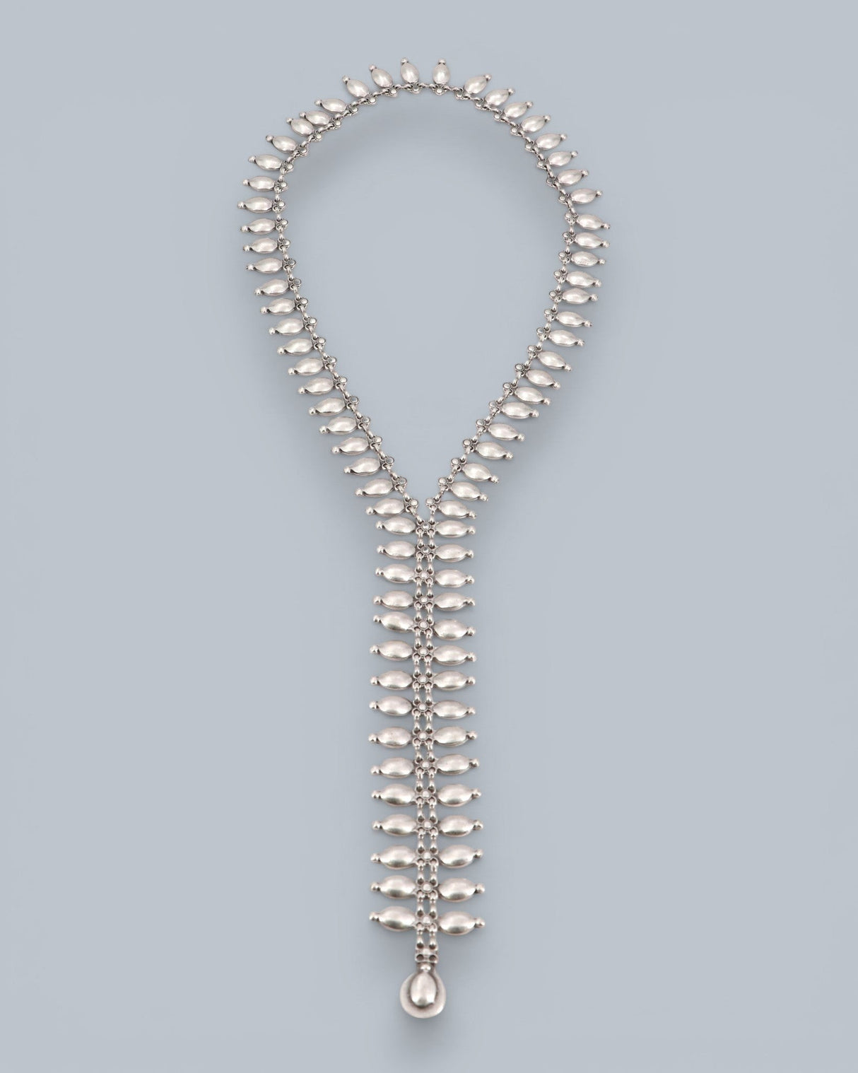 Cultural Elements silver metal lariat necklace with oval and marquise-shaped links and a teardrop pendant.