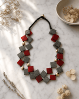Double-Strand Deep Red and Gray Horn Necklace with Brass Accents — necklaces, editorial marble lifestyle photo