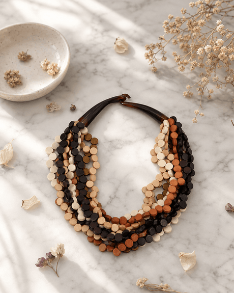 Wooden twist pendant necklace with earthy tones displayed on white marble surface