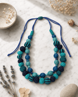 Fair Trade Acai Beads and Iraca Hand-woven Sea Tones Necklace, Colombia — necklaces, editorial marble lifestyle photo