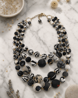 Four strand Kantha necklace with colorful fabric beads displayed on a white marble surface
