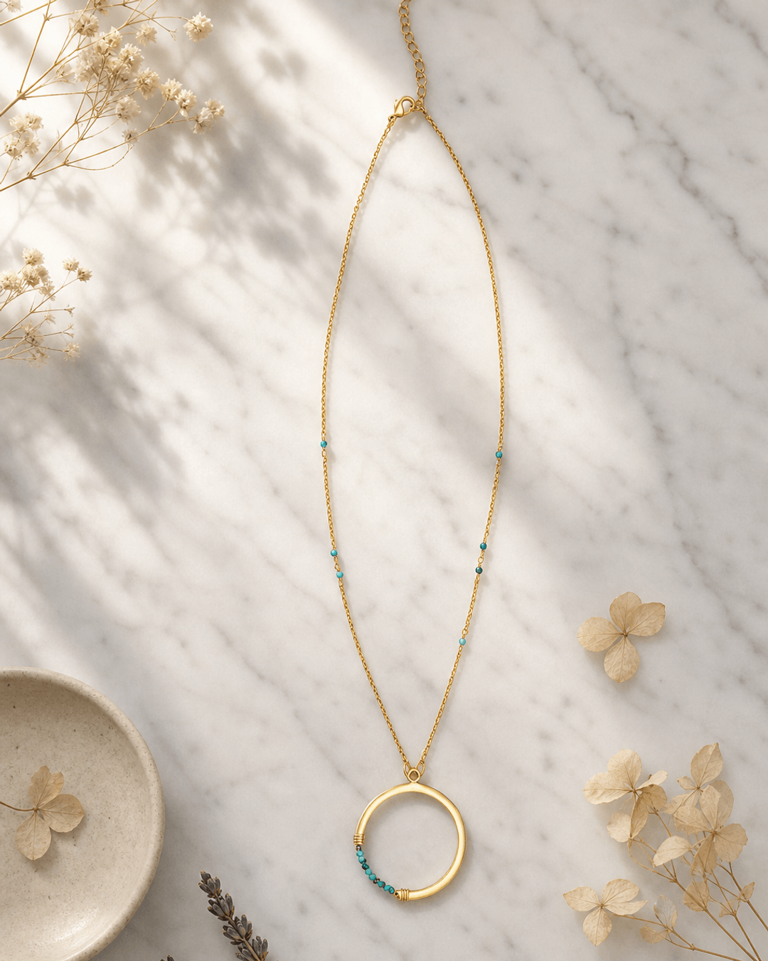 Gold-Plated Brass Circle Pendant Necklace with Turquoise Bead Accents — necklaces, editorial marble lifestyle photo