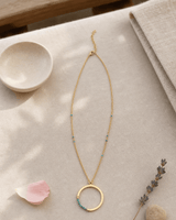 Gold-Plated Brass Circle Pendant Necklace with Turquoise Bead Accents — necklaces, meditation corner lifestyle photo