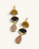 Close-up detail of gold-plated triple stone cat eye drop earrings showing gold bezel connectors and faceted stones