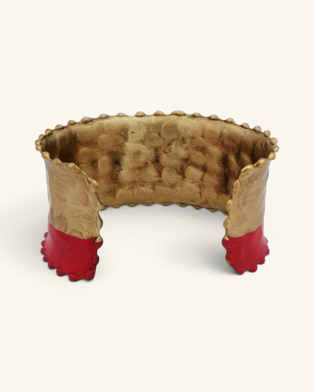 Hand-hammered brass cuff bracelet interior view showing hammered texture, red painted band at base with scalloped dot edging