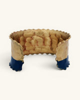 Hand-hammered brass cuff bracelet interior view showing raw hammered brass surface, beaded top edge, and indigo painted lower cuff ends
