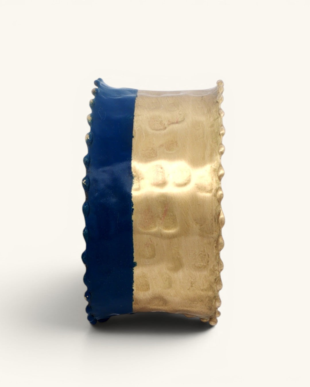 Hand-hammered brass cuff bracelet side view on white background showing the two-tone indigo and gold split and beaded scalloped edges