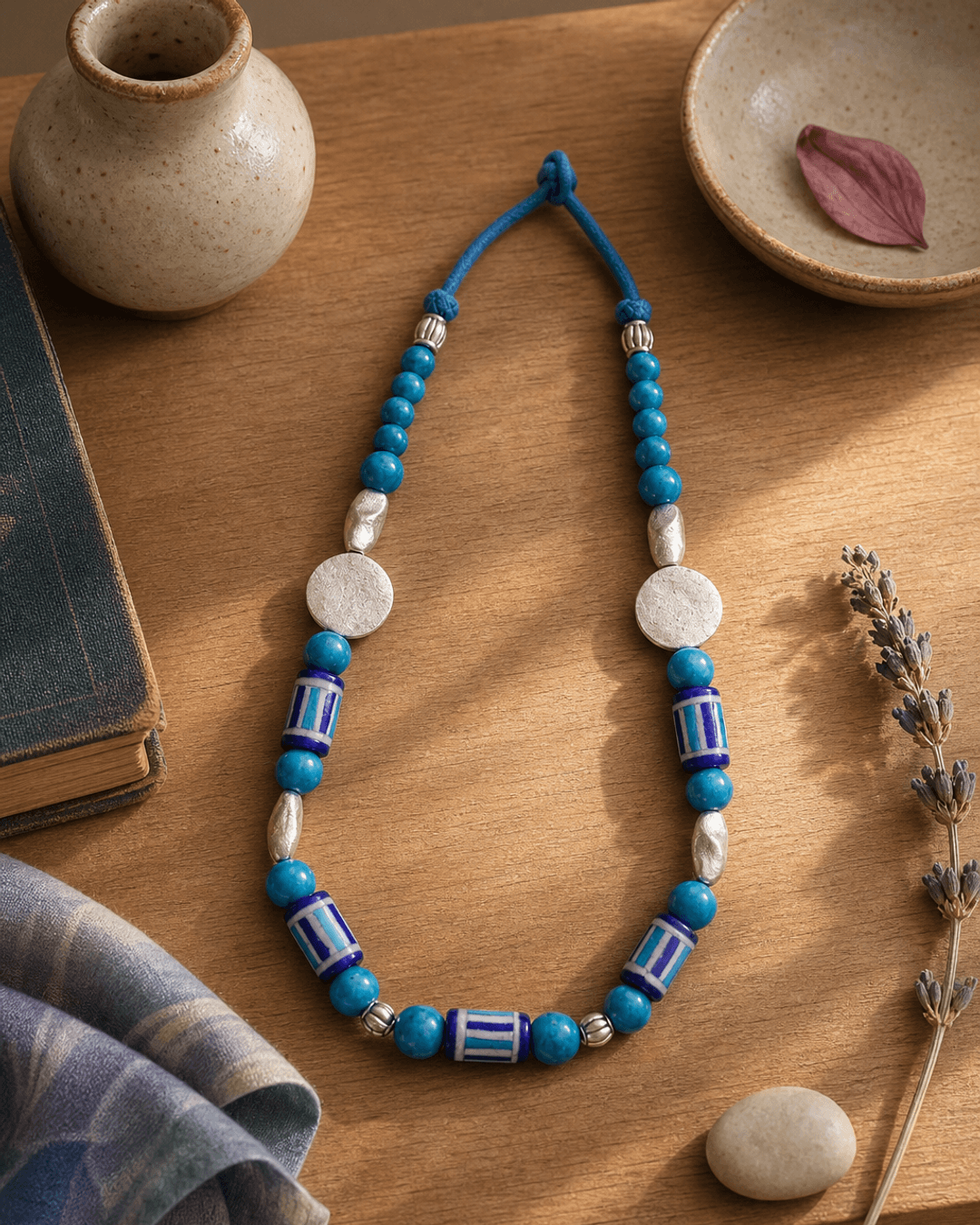 Hand-Painted Blue Pottery Bead Necklace with Metal Accents — necklaces, sunlit shelf lifestyle photo