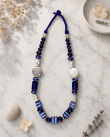 Hand-Painted Ceramic Bead Necklace with Metal Accents — necklaces, editorial marble lifestyle photo