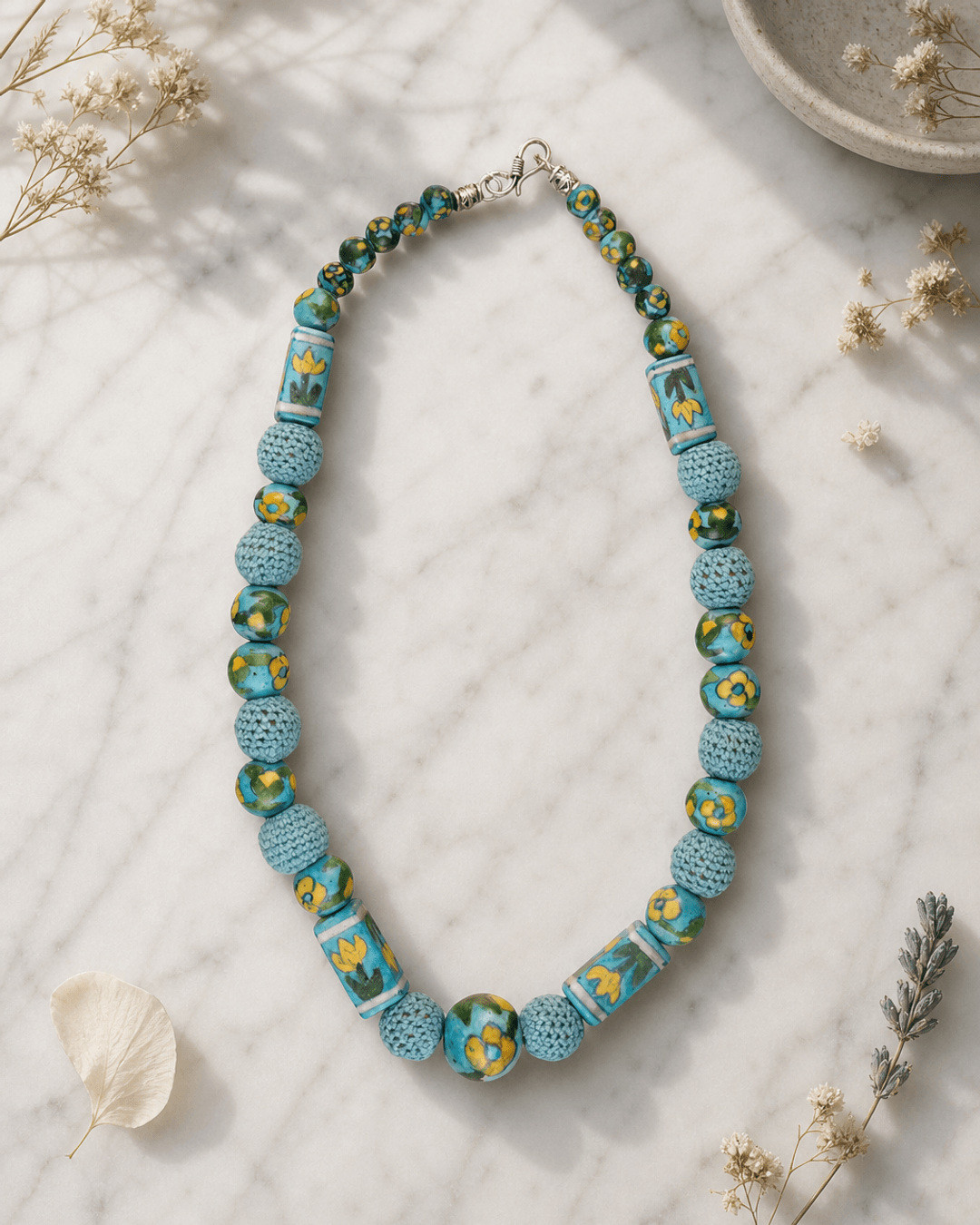 Hand-Painted Floral Ceramic Bead Necklace with Crochet Work — necklaces, editorial marble lifestyle photo