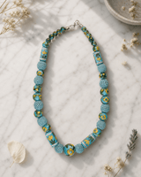 Hand-Painted Floral Ceramic Bead Necklace with Crochet Work — necklaces, editorial marble lifestyle photo