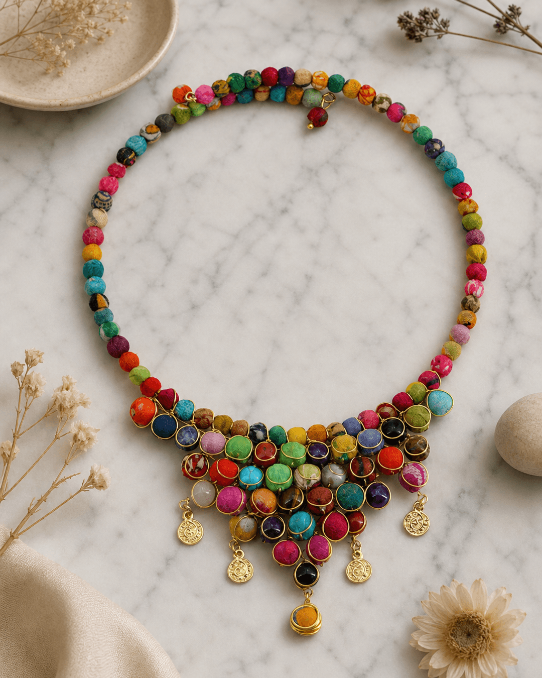Handmade multicolor textile and gemstone choker necklace displayed on white marble surface