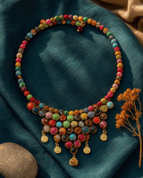 Handmade multicolor textile and gemstone choker necklace with close-up macro detail and soft bokeh background