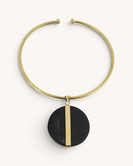 Horn and brass disc choker necklace front view, round black horn pendant with vertical brass bar on gold open collar
