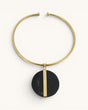 Horn and brass disc choker necklace front view, round black horn pendant with vertical brass bar on gold open collar