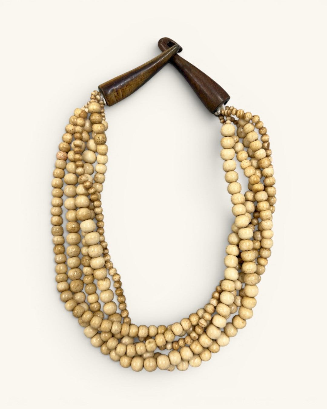 Five-strand Indian bone bead necklace on white background, horn hook closure fastened, viewed from a slight left angle