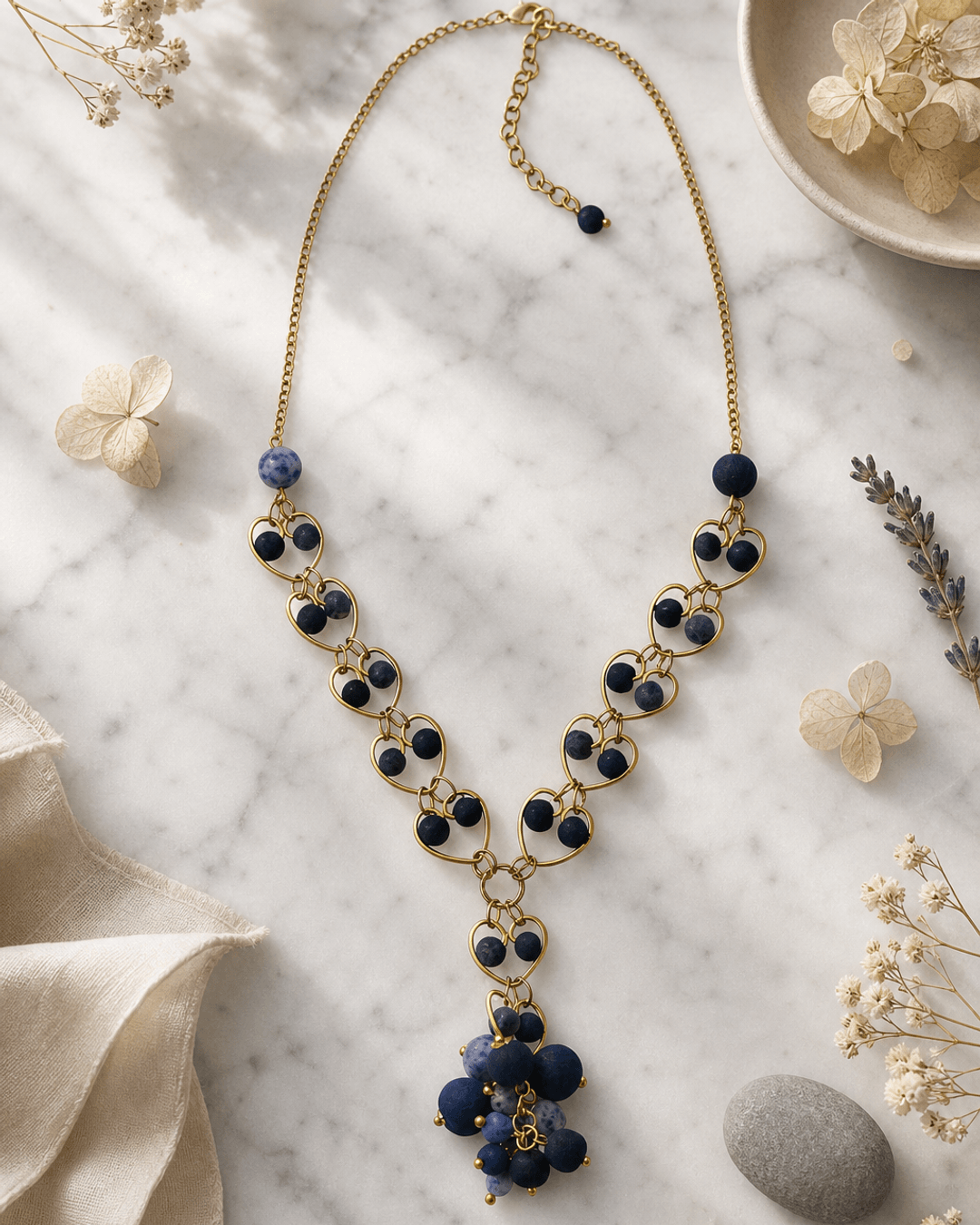 Indigo blue heart pendant link necklace displayed on white marble surface