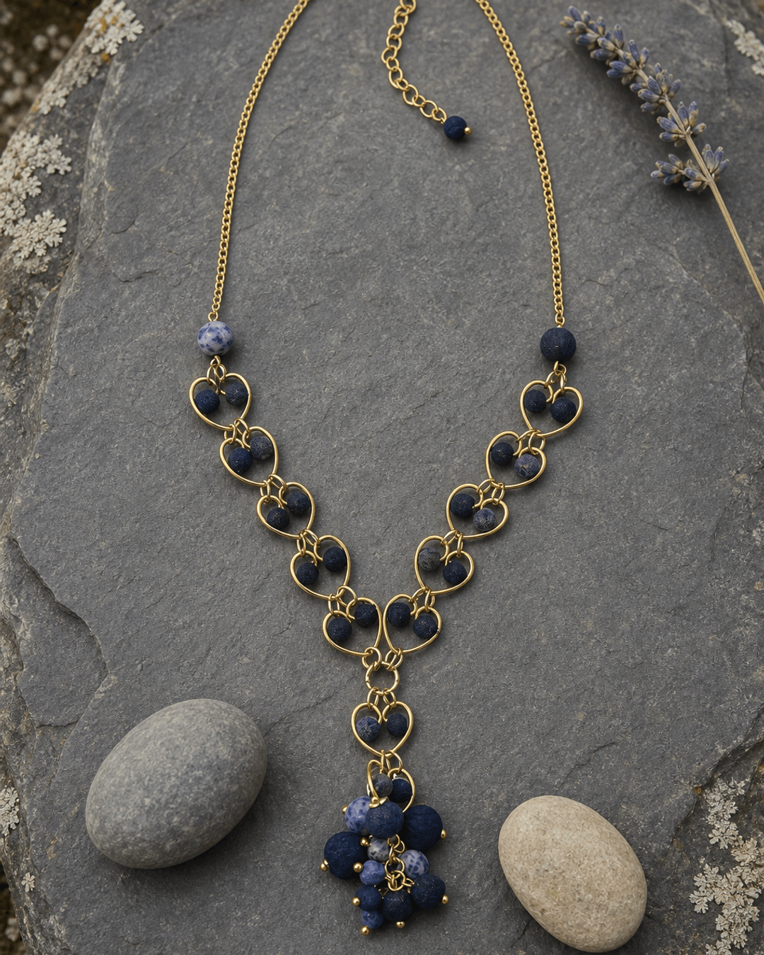 Indigo heart link necklace with blue gemstone pendant displayed on outdoor garden stone slate