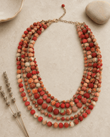 Handmade kantha five-strand layered necklace displayed on a vanity, featuring colorful fabric-wrapped beads and boho textile design