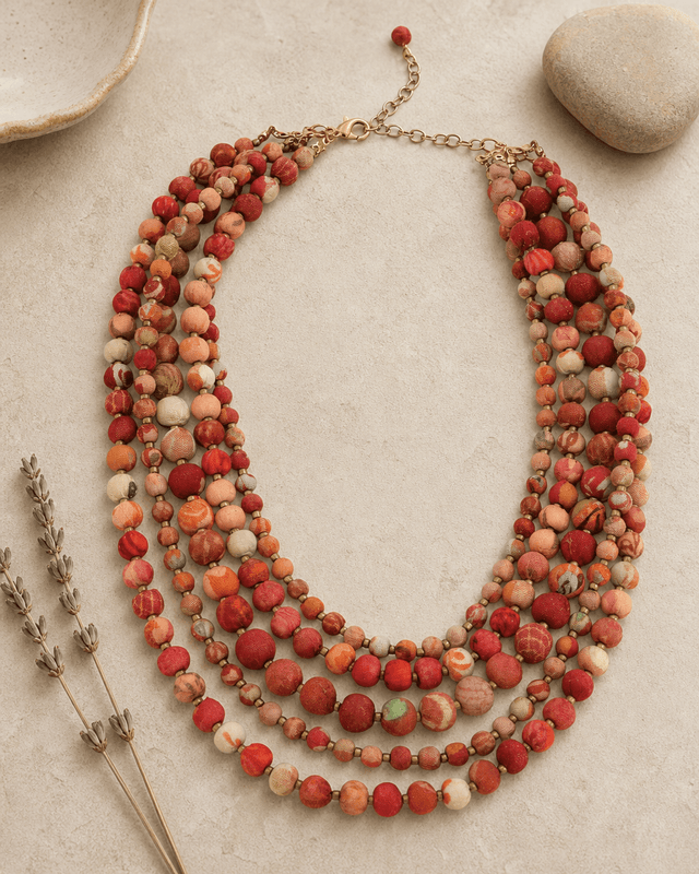 Handmade kantha five-strand layered necklace displayed on a vanity, featuring colorful fabric-wrapped beads and boho textile design