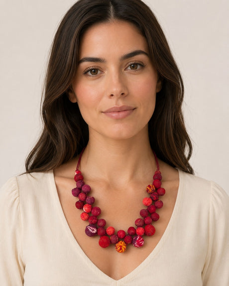 Kantha recycled textile layered bead necklace in red worn by a woman in a white v-neck top, showing length at collarbone