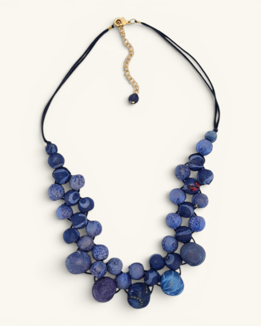 Kantha recycled sari textile bead layered necklace in indigo blue on white background showing bead texture and cord detail