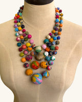 Kantha recycled textile four-strand statement necklace on a beige dress form showing graduated bead sizing and full drape