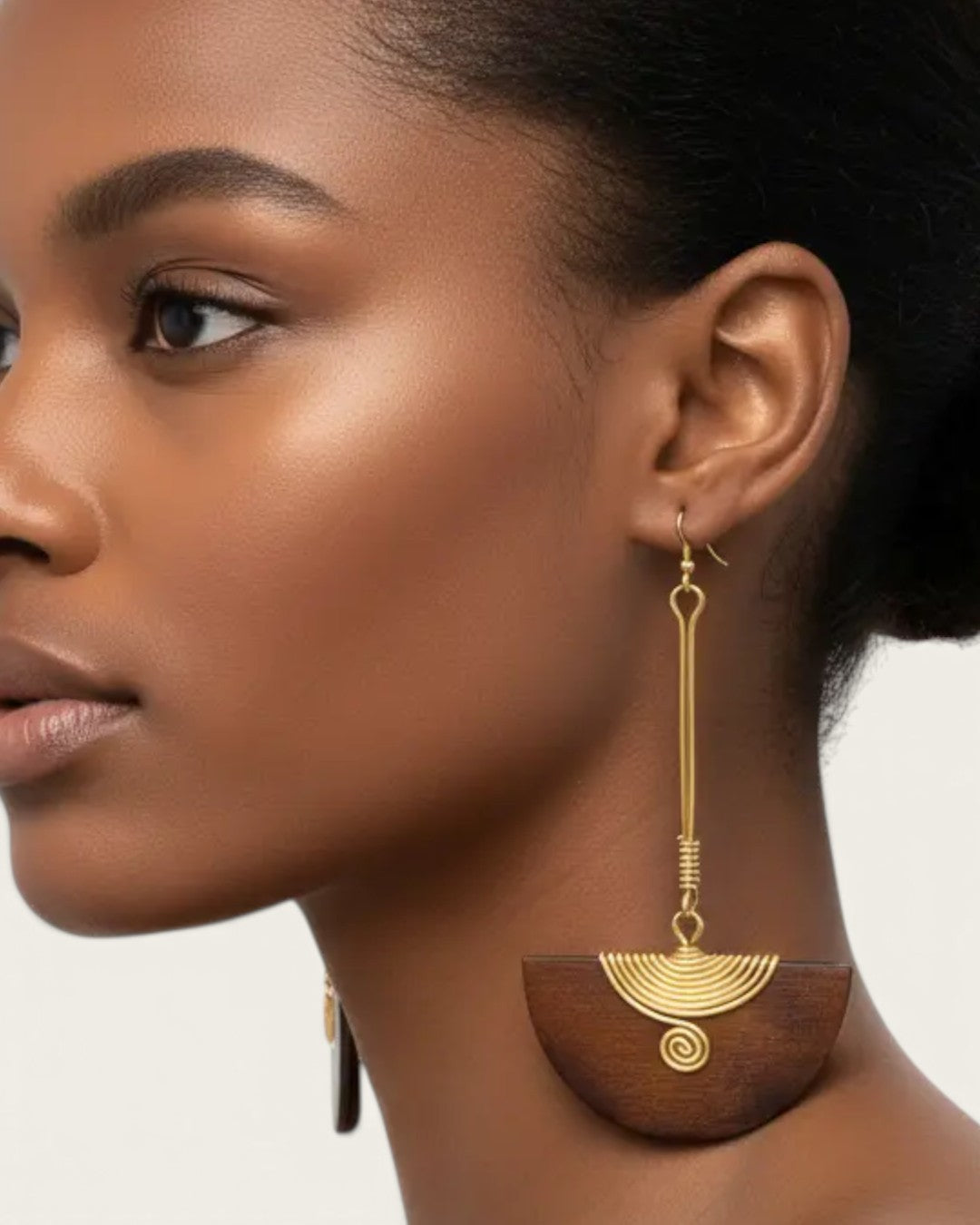 Kenyan brass and wood half-moon drop earrings worn on model in side profile, showing full length of the long brass bar drop
