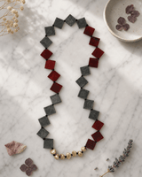 Long Red and Gray Square Horn Necklace with Brass Accents — necklaces, editorial marble lifestyle photo