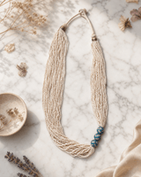Multi-Strand White Glass Bead Necklace with Hand-Painted Ceramic Accents — necklaces, editorial marble lifestyle photo