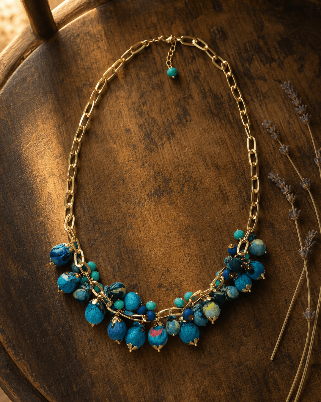 Blue textile beaded necklace with vibrant rim lighting highlighting woven fabric beads and layered strand detail