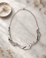 Paper Curl Design Metal Necklace — necklaces, editorial marble lifestyle photo