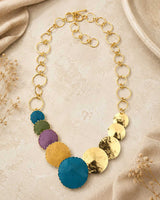 Close-up detail of hand-forged patina brass disc necklace highlighting hammered disc texture and aged brass patina finish