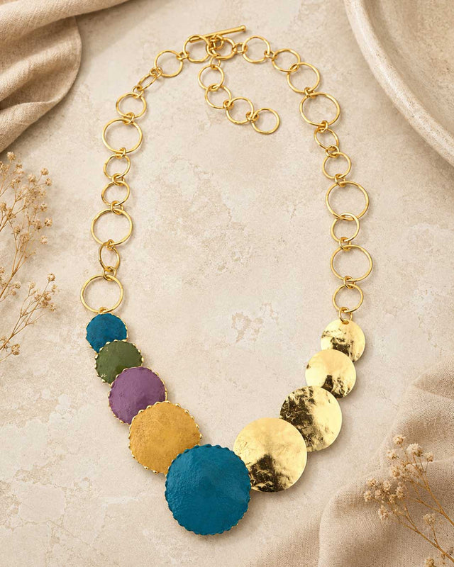 Close-up detail of hand-forged patina brass disc necklace highlighting hammered disc texture and aged brass patina finish