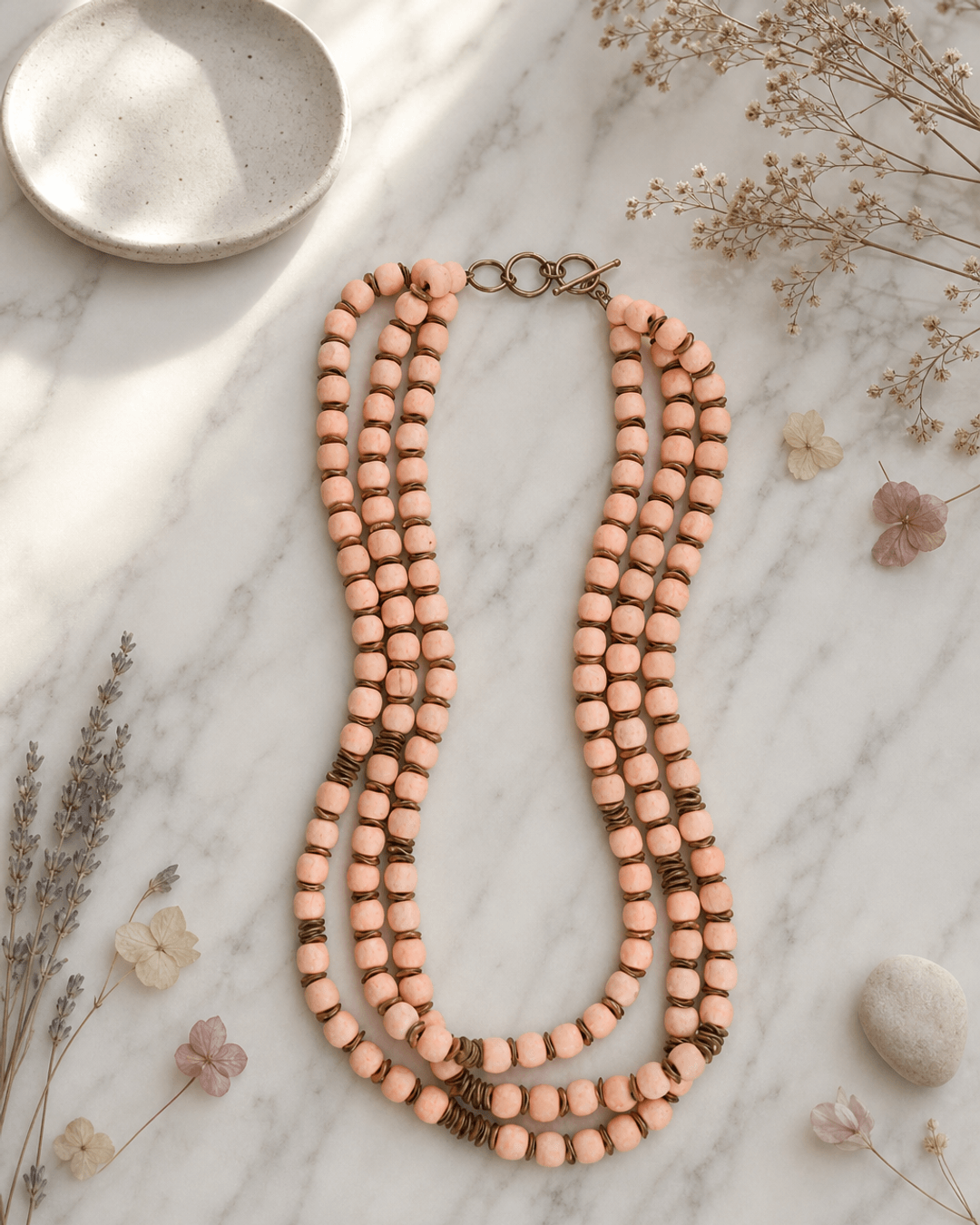 Peach-Pink Multi-Strand Wood Bead Necklace with Brass Accents — necklaces, editorial marble lifestyle photo