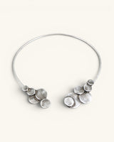 Silver-plated pewter collar necklace shown open on white background, stacked disc clusters visible at both wire ends