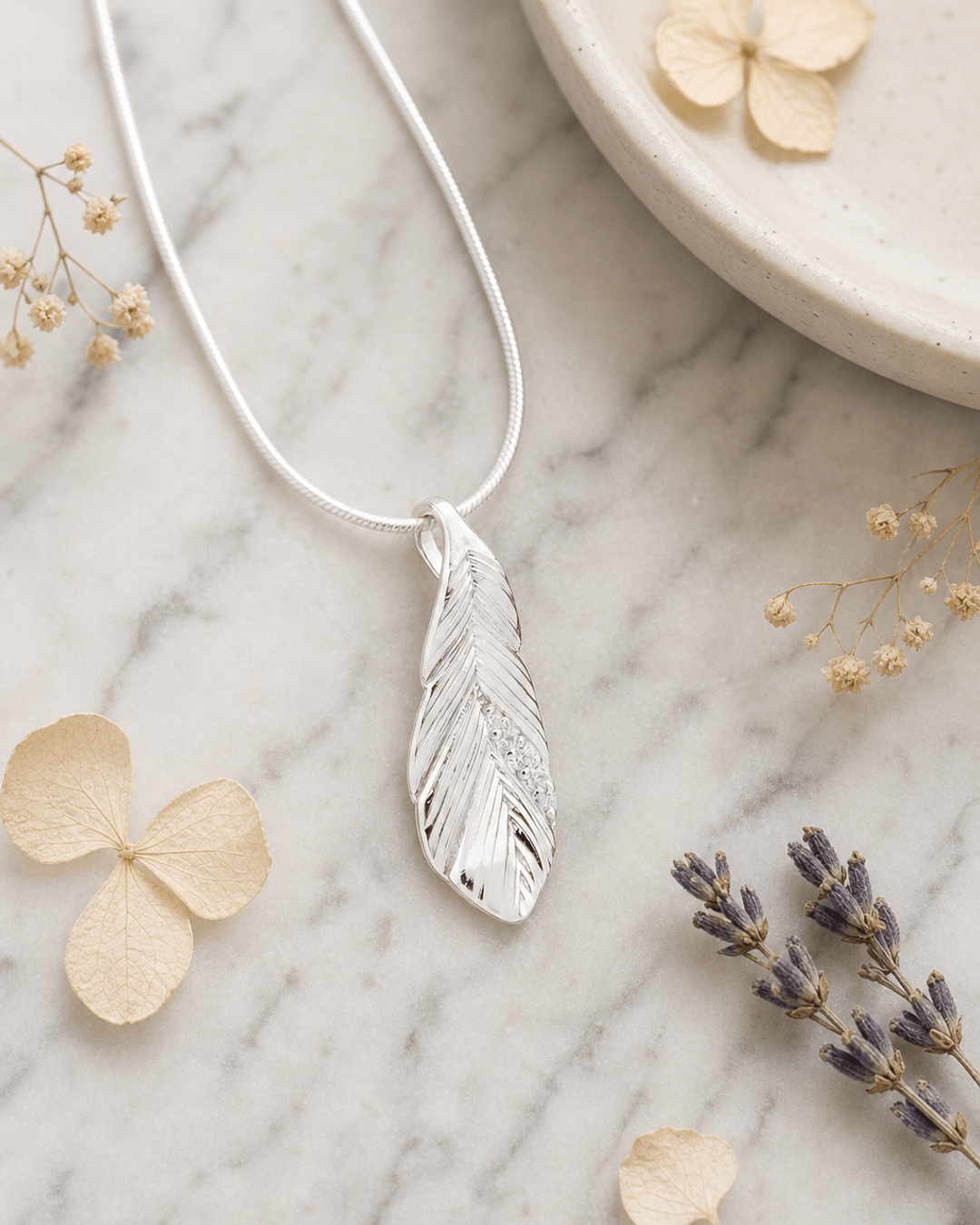 Silver and Crystal Textured Feather Pendant — charms & pendants, editorial marble lifestyle photo