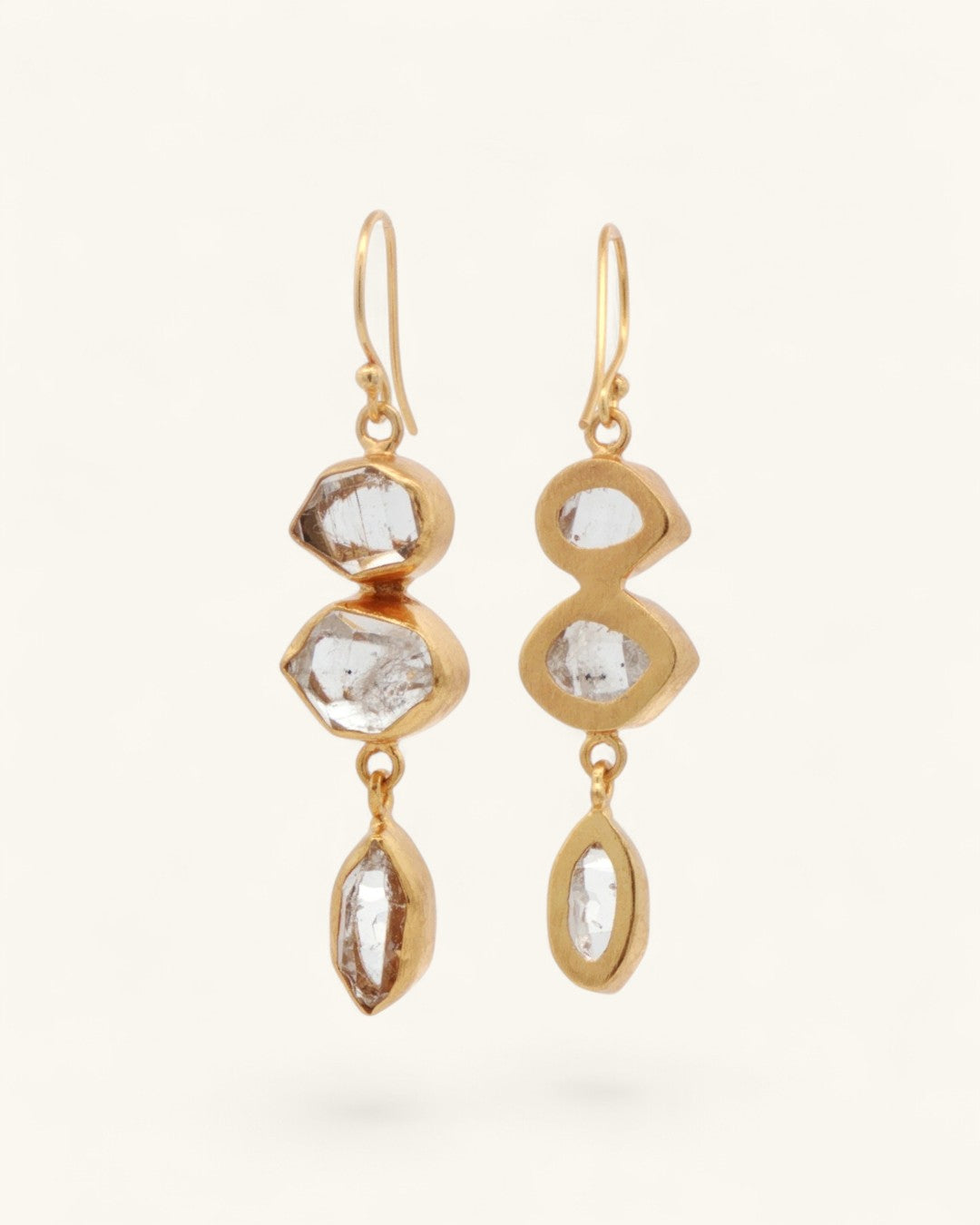 Triple Herkimer quartz gold-plated drop earrings at an angle, showing gold bezel back structure and varied stone settings