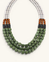 Close detail of triple strand serpentine and vulcanite necklace showing green tumbled beads, brown round bead accents and black disc spacers