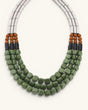 Close detail of triple strand serpentine and vulcanite necklace showing green tumbled beads, brown round bead accents and black disc spacers