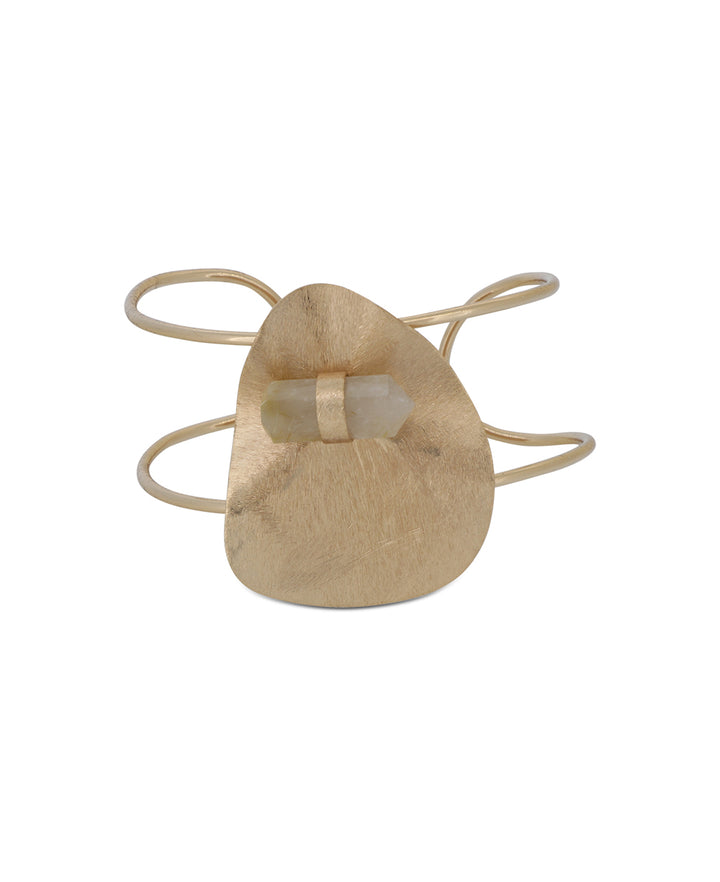 Close-up view of the snow quartz point set against a rose gold plated wide cuff bracelet